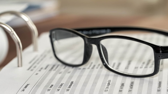 Brille auf einem aufgeschlagenen Ordner