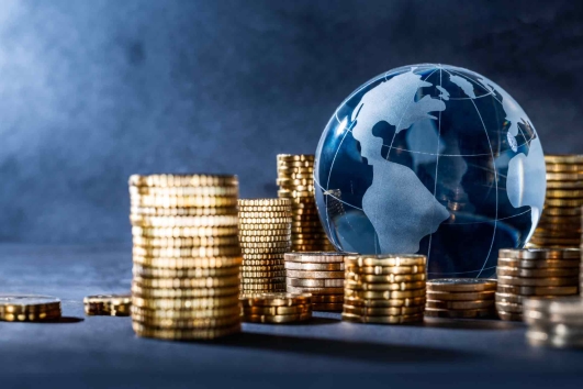 Blaue Weltkugel mit Münzstapel im Vordergrund