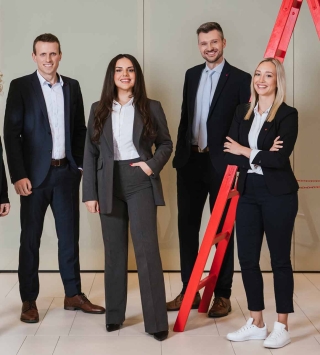 Fünf Oberbank Mitarbeiter stehen bei einer roten Leiter beisammen