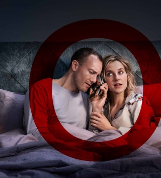 Frau und Mann sitzen aufrecht im Bett. Beide haben Geldbörse am Ohr und hören aufmerksam zu.