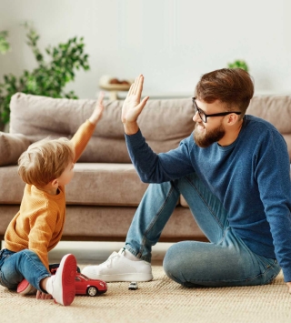 Vorsorgen & Versicherungen, Mann klatscht mit Sohn in die Hände